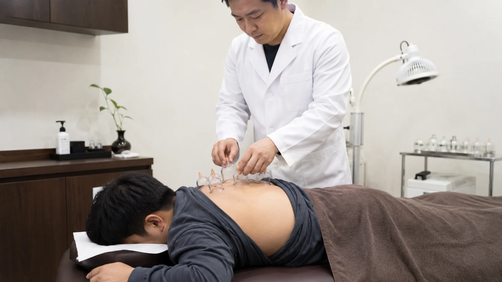 수영구 교통사고 야간진료|한의원에서 환자의 등에 부항 치료를 하는 모습